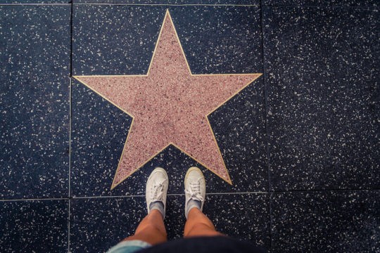 Girl standing in front of star on Hollywood Boulevard