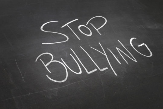 The words “stop bullying” written on a black chalkboard