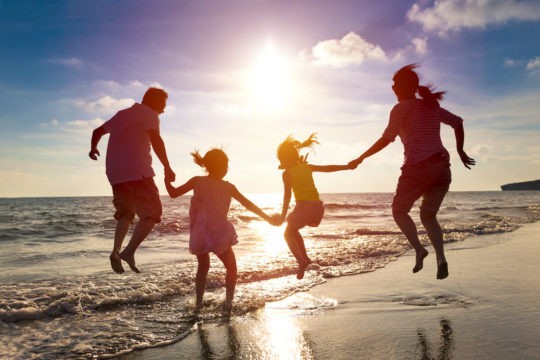 Family jumping together on a beach