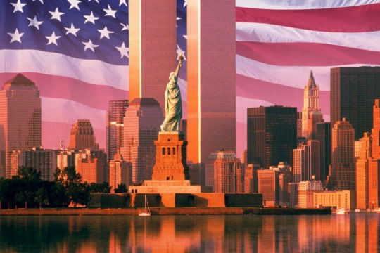 Statue of liberty and world trade center with American flag in background
