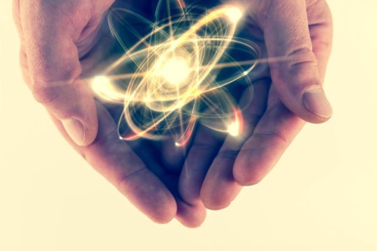 Atomic orbiting particle being held in cupped hands