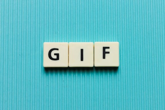 ‘GIF’ spelled on white tiles on a bright blue background.