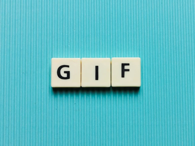 ‘GIF’ spelled on white tiles on a bright blue background.